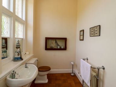 A bathroom with a sink toilet towel rack and decorative items at North Wing Middleton Hall Estate near Belford