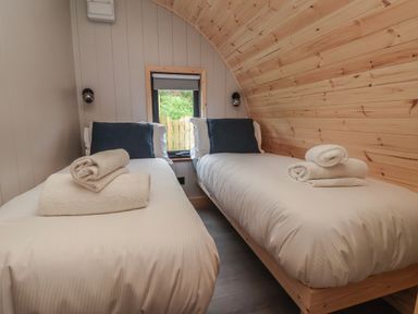 A small bedroom with two single beds and rolled towels on each bed at Lapwing in Chapel Le Dale near Ingleton