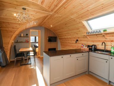An open kitchen and dining area with wooden walls and ceiling at Oyster Catcher Chapel Le Dale near Ingleton