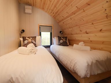 A bedroom with two single beds rolled towels and bird cushions at Oyster Catcher Chapel Le Dale near Ingleton