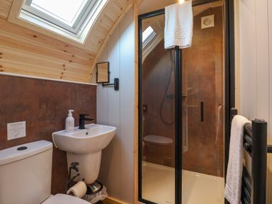A bathroom with a toilet sink shower and towel rack at Heron in Ingleton