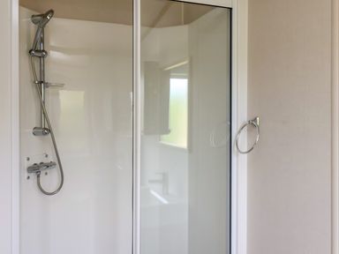 A bathroom with a shower area and a towel ring at Aspen Lodge in Whitby