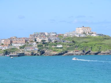 A coastal town with buildings on a hill overlooking the sea with boats in the water at 17 Cliff Edge in Newquay