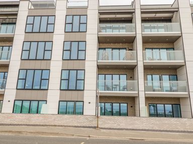 The exterior facade of a modern apartment building with multiple balconies and large windows at 17 Cliff Edge in Newquay