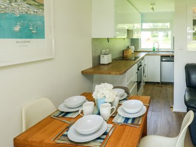 A kitchen and dining area with a table set for four and kitchen appliances at 61 Norton Park in Dartmouth