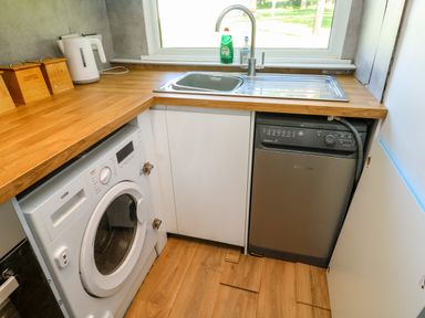 A kitchen corner with a washing machine kettle sink and dishwasher at 61 Norton Park in Dartmouth