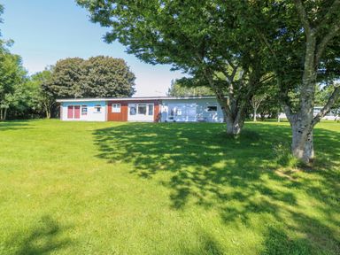 A single-story house with a large lawn and several trees at 61 Norton Park in Dartmouth