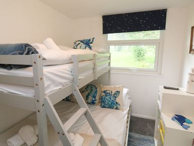 A bedroom with a bunk bed and ocean themed pillows near a window at 61 Norton Park in Dartmouth