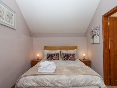 A bedroom with a double bed and bedside tables with lamps at Peace Cottage Queens Nympton near South Molton