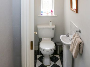 A small bathroom with a toilet sink towel and window at 23 Cois Caol in Skibbereen County Cork