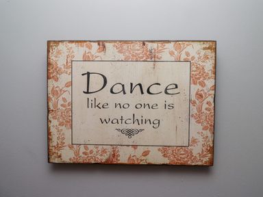 A decorative sign on a wall with the quote Dance like no one is watching at Woodcutters Cottage in Park Village near Haltwhistle
