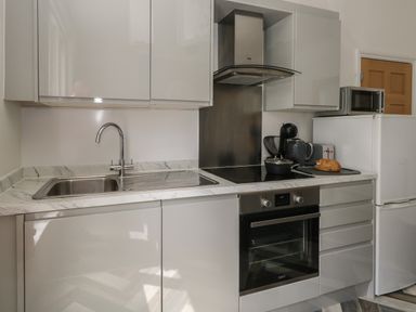 A kitchen with a sink stove oven refrigerator microwave and countertop appliances at Flat 2 - Studland in Bournemouth