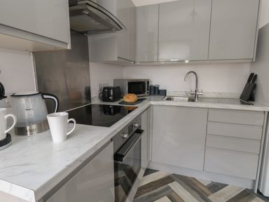 A kitchen with a countertop kettle cups toaster microwave sink and knives at Flat 4 - Hengistdury Bournemouth