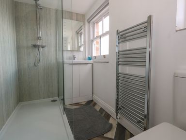 A bathroom with a walk-in shower sink with cabinet mirror window and heated towel rail at Flat 4 - Hengistdury in Bournemouth