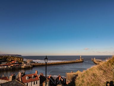 A view of the sea and piers with houses at Hazel Lodge in Whitby