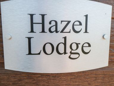 A sign with the name Hazel Lodge
