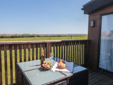 An outdoor area with a table set with drinks and food at Hazel Lodge in Whitby