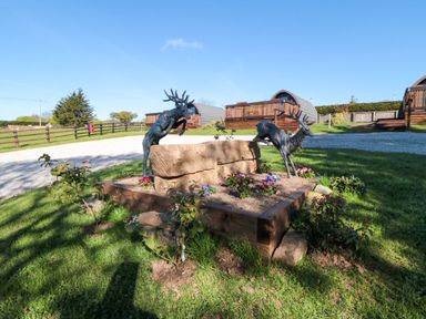 An outdoor area with sculptures and a flower bed at Juniper Lodge in Whitby