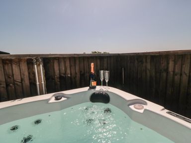 A hot tub with champagne and glasses at Willow Lodge in Whitby