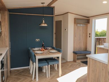 A dining area with a table and chairs at Magnolia Lodge in Whitby