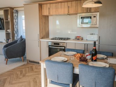 A kitchen with dining table and appliances at Magnolia Lodge in Whitby