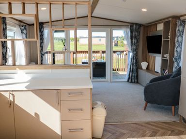 A living room with sofa and television at Magnolia Lodge in Whitby
