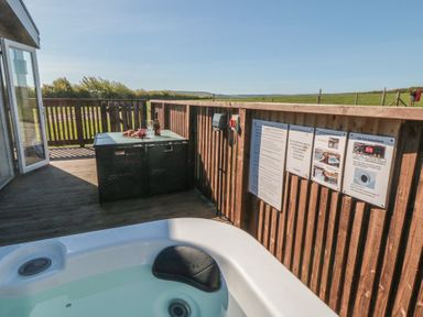 An outdoor area with a hot tub and seating at Magnolia Lodge in Whitby