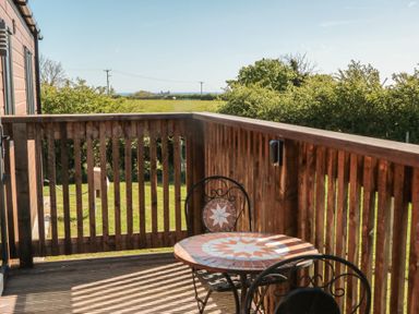 A balcony with a table and chairs at Magnolia Lodge in Whitby