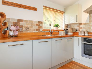 A kitchen with wooden countertop and tiled backsplash at 3 Lake View in Lanreath