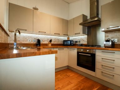 A kitchen with wooden countertops cabinets and stainless steel appliances at 1 Hedgerows in Lanreath