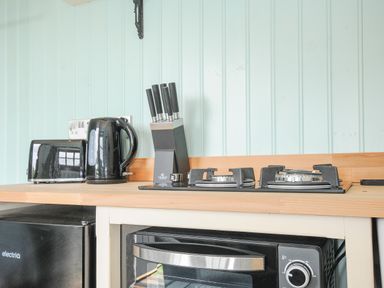 A kitchen countertop with a black toaster kettle knife block and a stove at Bracken in Broad Langdon near Wainhouse Corner