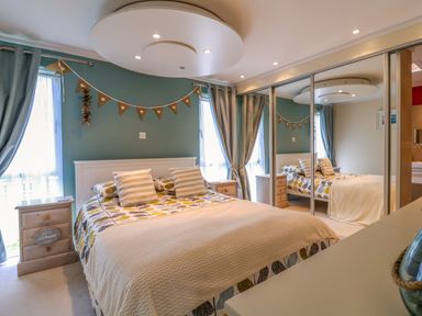 A bedroom with a bed pillows bedside tables and mirrored wardrobe doors at Owls Retreat Lodge 11 Near Aldeburgh