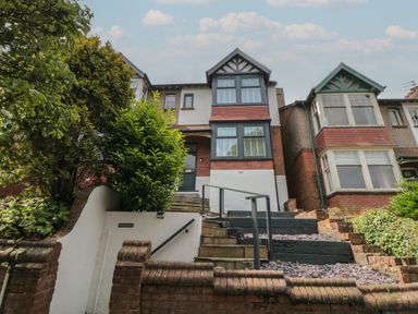A front view of a two-story house with stairs and plants at Thirty Four By the Sea in Scarborough