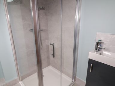 A bathroom with a glass shower enclosure and a sink with a chrome faucet at ARD NA GHAOITHE in Loughanure County Donegal