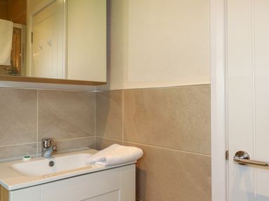 A bathroom sink with a faucet and folded towel on the countertop at 43 The Maples in Sticker