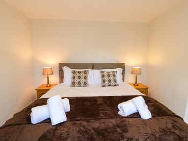 A bedroom with a double bed with pillows and bedside tables with lamps at Holborn Cottage Blencathra Street Keswick