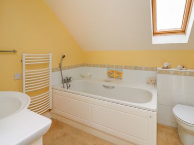 A bathroom with a bathtub white towel rack and a skylight window at West Dairy near Newport Pembrokeshire