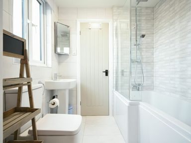 A bathroom with a toilet sink and bathtub with shower at East Farm Croft in Embleton