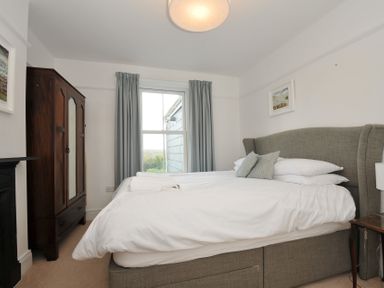 A bedroom with a bed and wardrobe at 2 Glyddins 1910 in Rock