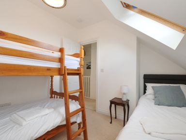 A bedroom with a bunk bed and a single bed at 2 Glyddins 1910 Rock