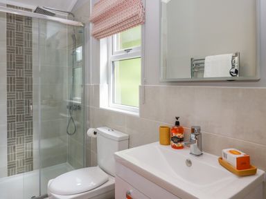 A bathroom with a toilet sink shower area and window at Waterside Lodge 55A Bowness White Cross Bay near Windermere