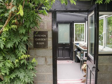 A doorway with a sign reading kitchen garden room and an open black door showing an interior with a sink and countertop at Pink Granite Garden of Ireland near Tinahely County Wicklow