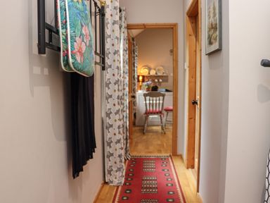 A hallway with a red runner rug leading to a room with chairs and a table at Pink Granite Garden of Ireland near Tinahely County Wicklow