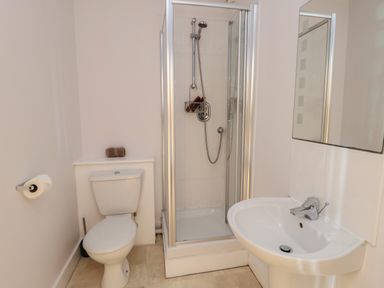 A bathroom with a toilet shower enclosure and sink at Dunes in Rhosneigr