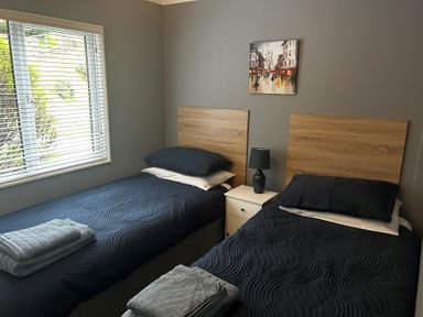 A bedroom with two beds and a painting at 22 Two Little Ducks in Lynton