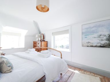 A bedroom with a wooden bed and dresser with a mirror and a lamp at Hilldene in Treknow