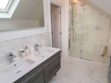 A bathroom with a double sink vanity and a glass-enclosed shower at Amelia's Point in St Ives