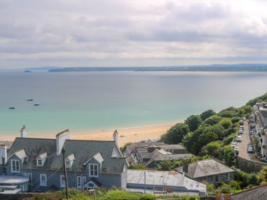 A coastal view with houses trees and cars near a beach and ocean at Amelia's Point in St Ives