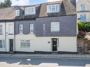 A street view of a two-story house with a tiled roof and multiple windows at Stone's Throw Cottage in Launceston