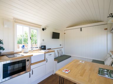 A kitchen and dining area with built in benches and cushions at Strathmore in Burnside near Forfar